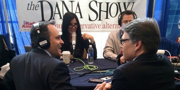 TO GO WITH AFP STORY by Ivan Couronne Texas governor Rick Perry (R) shakes hands with Matt Bevin, a Tea party-backed US Senate candidate from Kentucky, while the two joined conservative radio host Dana Loesch (2nd L) on her show March 7, 2014, broadcasting from CPAC, the annual conference for American conservatives. AFP PHOTO/MICHAEL MATHES (Photo credit should read MICHAEL MATHES/AFP/Getty Images)