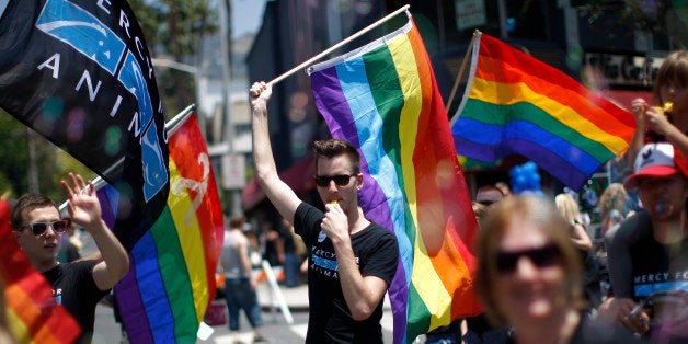 WEST HOLLYWOOD, CA - JUNE 8: A man carries a rainbow flag and whistle at the LA Pride Parade on June 8, 2014 in West Hollywood, California. The LA Pride Parade and weekend events this year are emphasizing transgender rights and issues. The annual LGBT pride parade begin in 1970, a year after the Stonewall riots, and historically attracts more than 400,000 spectators and participants. (Photo by David McNew/Getty Images)