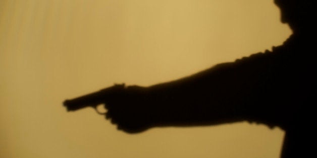 Shadow of man pointing gun, side view