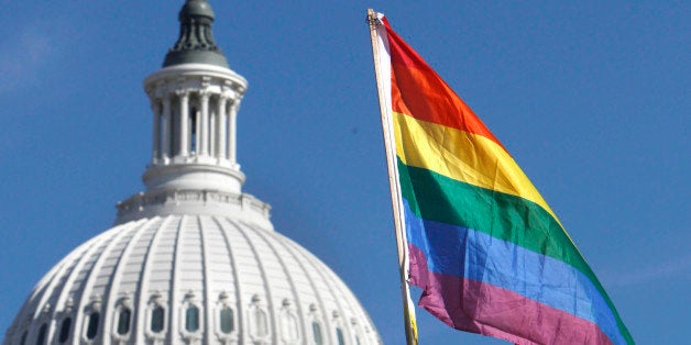 Daniel Raeder, 17, of Rockville, Md., holds a rainbow flag by the Capitol as thousands of gay rights advocates rally in Washington, on Sunday, Oct. 11, 2009. (AP Photo/Jacquelyn Martin)