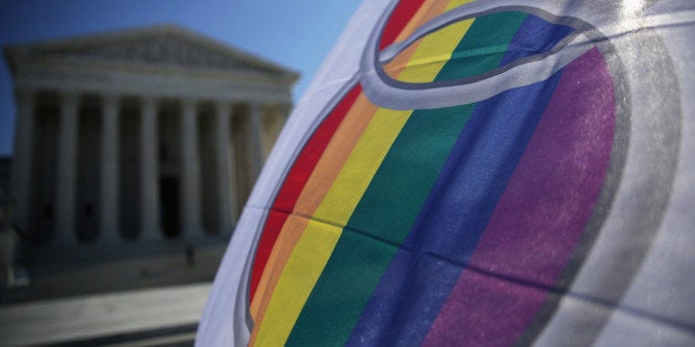 WASHINGTON, DC - JANUARY 09: An activist flies a 'marriage pride flag' outside the U.S. Supreme Court January 9, 2015 in Washington, DC. The justices of the Supreme Court were scheduled to meet to determine whether the court will take up any of the five pending state-banned same-sex marriage cases in Ohio, Tennessee, Michigan, Kentucky and Louisiana. (Photo by Alex Wong/Getty Images)