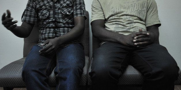 This picture taken on January 12, 2012 shows a gay couple, who wish to remain anonymous, who fled deadly persecution in their home country due to their sexual-orientation, during an interview in the Kenyan capital, Nairobi. Lesbian, gay, bisexual and transgender (LGBT) people are increasingly fleeing across international borders in the East African region came to this urban jungle [Nairobi] seeking anonymity, explained an official running a programme that takes care of such refugees. Some have fled a strict application of Islamic law in Somalia, others are running from general sexual violence in the Democratic Republic of Congo and yet others have fled a climate of growing hostility elsewhere in east Africa The official who requested anonimity cites the new anti-homosexuality bill in neighbouring Uganda that touched off a wave of homophobia in neighbouring Uganda as an example of an increasing incidence of openly hostile environment for 'LGBT individuals'. AFP PHOTO/Tony KARUMBA (Photo credit should read TONY KARUMBA/AFP/Getty Images)