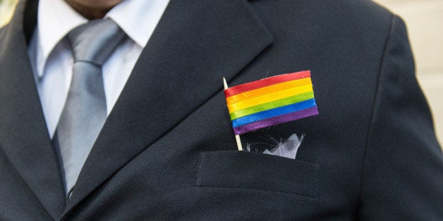 The father of a bride wears a rainbow flag during the wedding ceremony at the Court of Justice of the State of Rio de Janeiro in Rio de Janeiro, Brazil, on December 8, 2013. 130 gay couples are getting married in the first massive wedding ceremony since the first gay marriage in Rio de Janeiro in 2011. AFP PHOTO / YASUYOSHI CHIBA (Photo credit should read YASUYOSHI CHIBA/AFP/Getty Images)