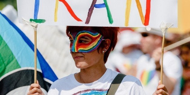 A woman holds up a sign reading 'One day we'll march in Iran' while taking part in the Christopher Street Parade in Hamburg, northern Germany, on August 2, 2014. AFP PHOTO / DPA/ MARKUS SCHOLZ GERMANY OUT (Photo credit should read MARKUS SCHOLZ/AFP/Getty Images)