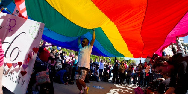 Demonstrators hold up a rainbow flag in front of the Supreme Court in Washington, Tuesday, April 28, 2015. The Supreme Court is set to hear historic arguments in cases that could make same-sex marriage the law of the land. The justices are meeting Tuesday to offer the first public indication of where they stand in the dispute over whether states can continue defining marriage as the union of a man and a woman, or whether the Constitution gives gay and lesbian couples the right to marry. ( AP Photo/Jose Luis Magana)