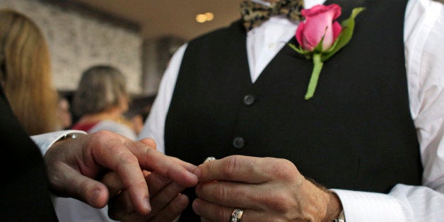 Steve Visano, 54, places a ring on his partner's hand during a group wedding ceremony at a hotel in honor of Florida's ruling in favor of same-sex marriage equality, Thursday, Feb. 5, 2015, in Fort Lauderdale, Fla. In January Florida became the 36th state where gay marriage in legal. (AP Photo/Lynne Sladky)