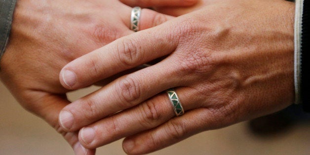 Army Capt. Michael Potoczniak, left, and Todd Saunders, of El Cerrito, Calif., show their wedding rings after they exchanged
