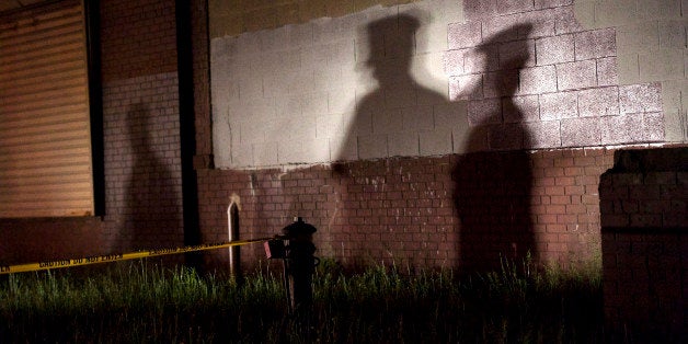 PHILADELPHIA, PA - MAY 13: The shadow of a police officer is cast onto a building near the wreckage of an Amtrak passenger t