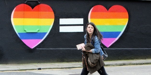 A woman walks past a mural in favour of same-sex marriages in Dublin on May 21, 2015. Ireland goes to the polls tomorrow to v