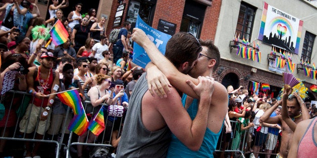 NEW YORK - JUNE 24: Revelers kiss in front of the Stonewall Inn during the New York City Gay Pride March on June 24, 2012 in New York City. The annual civil rights demonstration commemorates the Stonewall riots of 1969, which erupted after a police raid on a gay bar, the Stonewall Inn on Christopher Street. (Photo by Michael Nagle/Getty Images)