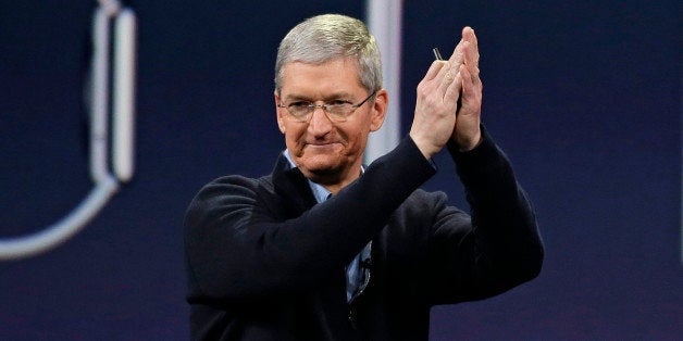 In this Monday, March 9, 2015 photo, Apple CEO Tim Cook applauds at the conclusion of the Apple "Spring Forward" launch event in San Francisco. Cook took a figurative victory lap at his companyâs annual shareholder meeting Tuesday, one day after he announced details about the new smartwatch Apple plans to sell next month. (AP Photo/Eric Risberg)