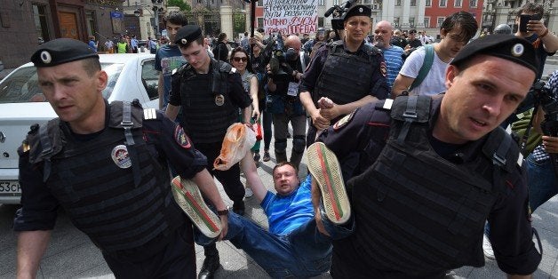 Russian riot policemen detain gay and LGBT rights activist Nikolai Alexeyev (C) during an unauthorized gay rights activists rally in central Moscow on May 30, 2015. Moscow city authorities turned down demands for a gay rights rally. AFP PHOTO/DMITRY SEREBRYAKOV (Photo credit should read DMITRY SEREBRYAKOV/AFP/Getty Images)