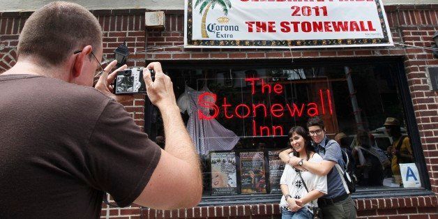 FILE - In this June 25, 2011 file photo Audrey Berry, left, and Paxx Moll, right, have their picture taken in front of the Stonewall Inn in New York. The National Park Service is launching an initiative to make places and people of significance to the history of lesbian, gay, transgender and bisexual Americans part of the national narrative. (AP Photo/Mary Altaffer,File)