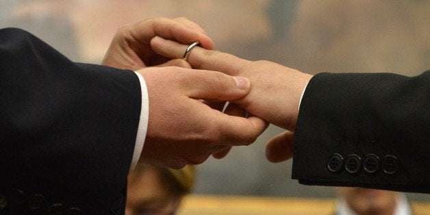 A same-sex couple exchanges rings after they registered their civil union at Rome's city hall on May 21, 2015 in Rome. The city of Rome organized today a 'Celebration Day' to registrate civil unions including same-sex ones. Italy's Justice Minister Andrea Orlando said yesterday the country needs a civil unions law and a draft bill by ruling Democratic Party (PD) should be presented in parliament by the end of July. AFP PHOTO / TIZIANA FABI (Photo credit should read TIZIANA FABI/AFP/Getty Images)