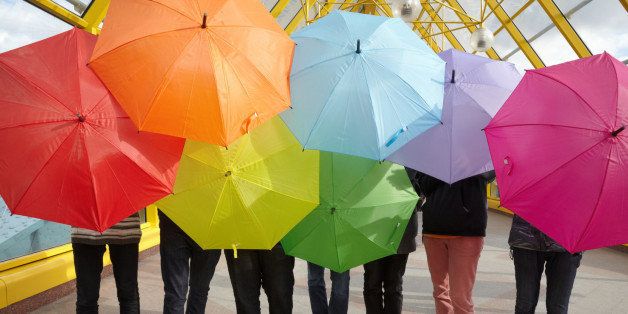 seven teens with opened umbrellas in pedestrian overpass