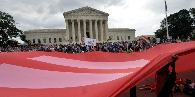 People wave a giant equality flag in celebration outside the Supreme Court in Washington, DC on June 26, 2015 after its historic decision on gay marriage. The US Supreme Court ruled Friday that gay marriage is a nationwide right, a landmark decision in one of the most keenly awaited announcements in decades and sparking scenes of jubilation. The nation's highest court, in a narrow 5-4 decision, said the US Constitution requires all states to carry out and recognize marriage between people of the same sex. AFP PHOTO/ MLADEN ANTONOV (Photo credit should read MLADEN ANTONOV/AFP/Getty Images)