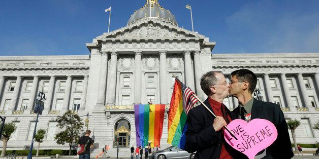 Gay rights advocates John Lewis, left, and his spouse Stuart Gaffney, with the group Marriage Equality USA, kiss across the street from City Hall in San Francisco, Friday, June 26, 2015, following a ruling by the U.S. Supreme Court that same-sex couples have the right to marry nationwide. (AP Photo/Jeff Chiu)