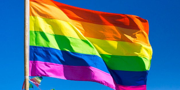 Rainbow flag against sky during gay pride parade