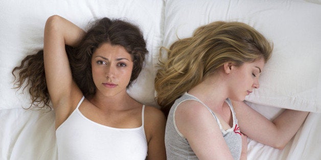 Young lesbian couple with relationship problems lying in bed.