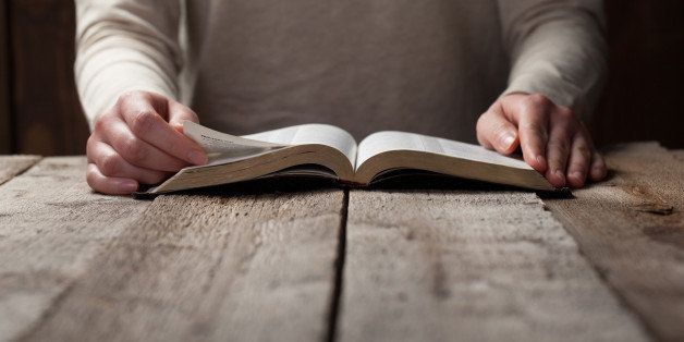 woman finger presses on bible book over wooden background