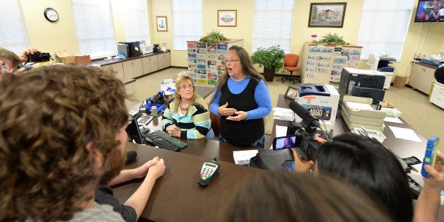 Rowan County Clerk Kim Davis, center, talks with protesters following her office's refusal to issue marriage licenses at the Rowan County Courthouse in Morehead, Ky., Tuesday, Sep. 1, 2015. Although her appeal to the U.S. Supreme Court was denied, Davis still refuses to issue marriage licenses. (AP Photo/Timothy D. Easley)