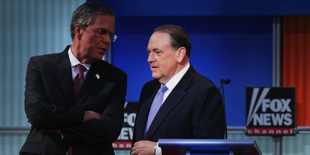 CLEVELAND, OH - AUGUST 06: Republican presidential candidate Jeb Bush and Mike Huckabee chat during a break in the first Republican presidential debate hosted by Fox News and Facebook at the Quicken Loans Arena on August 6, 2015 in Cleveland, Ohio. The top ten GOP candidates were selected to participate in the debate based on their rank in an average of the five most recent political polls. (Photo by Scott Olson/Getty Images)