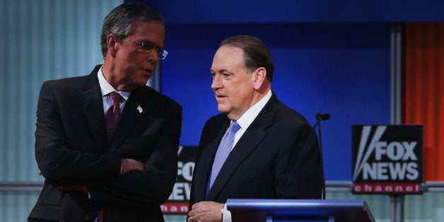 CLEVELAND, OH - AUGUST 06: Republican presidential candidate Jeb Bush and Mike Huckabee chat during a break in the first Republican presidential debate hosted by Fox News and Facebook at the Quicken Loans Arena on August 6, 2015 in Cleveland, Ohio. The top ten GOP candidates were selected to participate in the debate based on their rank in an average of the five most recent political polls. (Photo by Scott Olson/Getty Images)