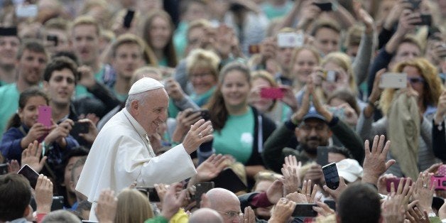 Pope Francis greets the crowd as he arrives for his weekly general audience at St Peter's square on September 30, 2015 at the Vatican. AFP PHOTO / ANDREAS SOLARO (Photo credit should read ANDREAS SOLARO/AFP/Getty Images)