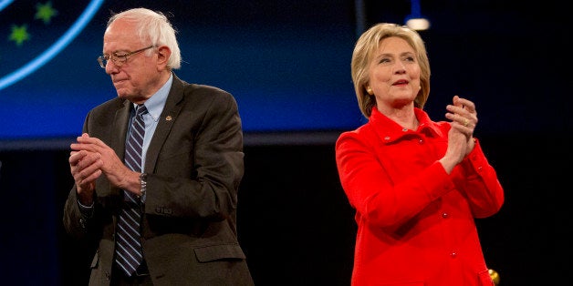 Hillary Clinton, former Secretary of State and 2016 Democratic presidential candidate, right, and Senator Bernie Sanders, an independent from Vermont and 2016 Democratic presidential candidate, applaud and stand on stage together during candidate introductions at the Jefferson-Jackson Dinner in Des Moines, Iowa, U.S., on Saturday, Oct. 24, 2015. With Vice President Joe Biden officially out of the presidential race, the nation's first nominating contest between front-runner Clinton and Sanders is gaining steam, according to a new Bloomberg Politics/Des Moines Register Iowa Poll. Photographer: Daniel Acker/Bloomberg via Getty Images 