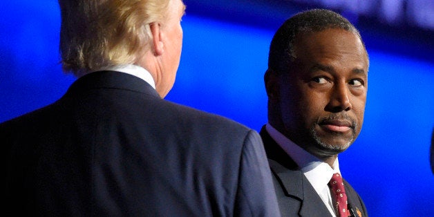 Ben Carson watches as Donald Trump takes the stage during the CNBC Republican presidential debate at the University of Colorado, Wednesday, Oct. 28, 2015, in Boulder, Colo. (AP Photo/Mark J. Terrill)