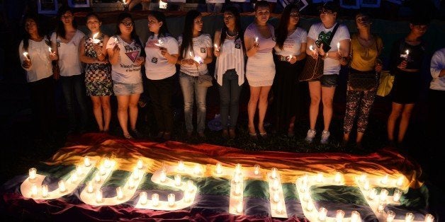 Protesters hold candles during a vigil inside the campus of the state university in Manila on October 24, 2014, to coincide with the burial of murdered transgender woman, Jennifer Laude. A US Marine accused of murdering a transgender woman was moved to the Philippines' military headquarters October 22, authorities said, following huge public pressure for him to be taken off an American warship. AFP PHOTO/TED ALJIBE (Photo credit should read TED ALJIBE/AFP/Getty Images)