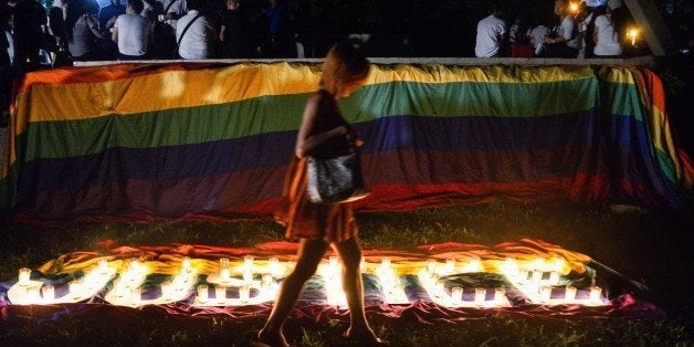 QUEZON CITY, PHILIPPINES - 2014/10/24: A transgender Filipino walks across the lit candles formed 'Justice' during a protest held at the University of the Philippines in Diliman on Friday. Jeffrey 'Jennifer' Laude was allegedy murdered by US marine Joseph Scott Pemberton. (Photo by Jansen Joel C. Romero/Pacific Press/LightRocket via Getty Images)