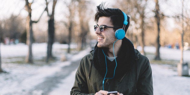 Young man texting on smartphone in the winter park