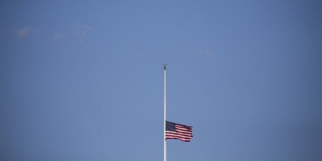 WASHINGTON, USA - DECEMBER 3: The American flag flys at half-staff above the White House December 3, 2015 in Washington, DC. after U.S. President Barack Obama signed a proclaimation ordering all flags to be flown at half-staff to honor the victims of Wednesday's mass shooting in San Bernardino, California. (Photo by Samuel Corum/Anadolu Agency/Getty Images)