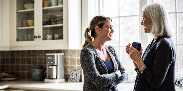 mother and daughter having coffee in kitchen