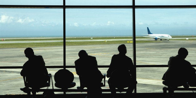 Businessmen watching airplanes on tarmac in airport