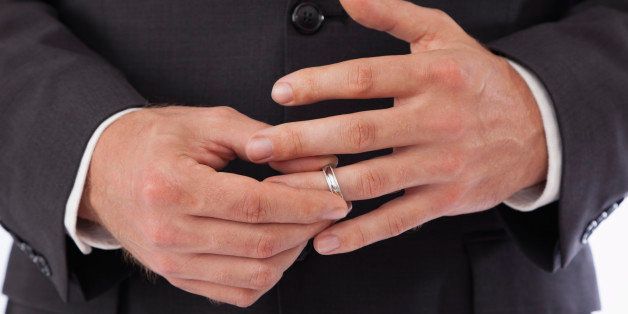 Close-up of man removing wedding ring from finger
