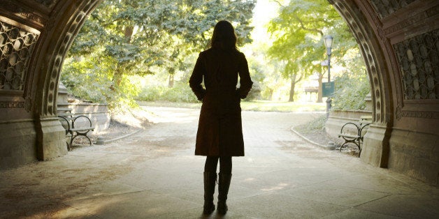 Woman walking through tunnel, rear view