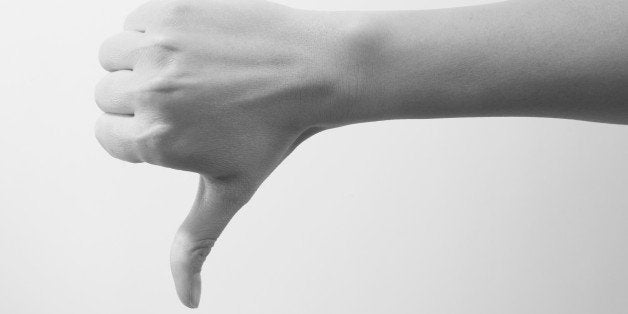 Woman giving thumbs down hand gesture, black and white image