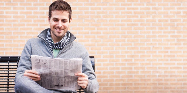 USA, New Jersey, Jersey City, Man on bench reading newspaper