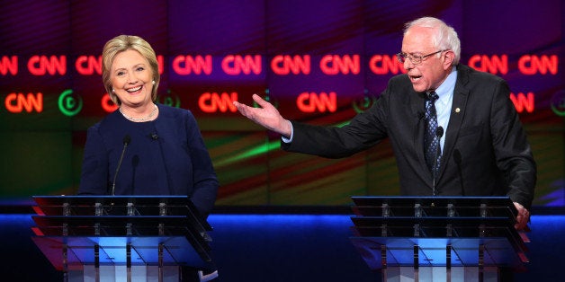 FLINT, MI - MARCH 06: Democratic presidential candidate Senator Bernie Sanders (D-VT) and Democratic presidential candidate Hillary Clinton speak during the CNN Democratic Presidential Primary Debate at the Whiting Auditorium at the Cultural Center Campus on March 6, 2016 in Flint, Michigan. Voters in Michigan will go to the polls March 8 for the state's primary. (Photo by Scott Olson/Getty Images)