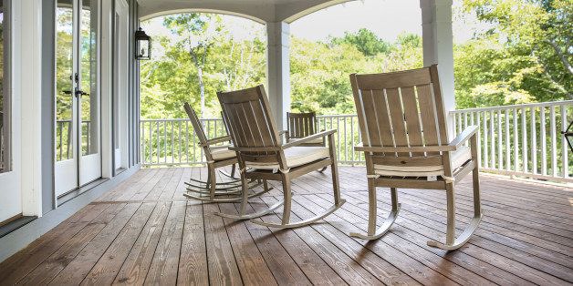 Rocking chairs grace a upper porch in a large lake front home in the Southern USA.