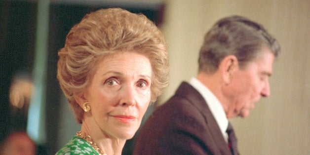 (Original Caption) Washington: First lady Nancy Reagan cast a pensive glance as President Reagan addresses a group of high school students from 'Direct Connection' at the White House. The students recently held a mini-summit of U.S. and Soviet students in Helsinki then met with Soviet leader Mikhail Gorbachev.