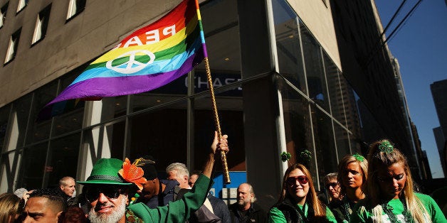 NEW YORK, NY - MARCH 17: A man holds up a Gay Pride flag at the annual St. Patrick's Day parade, one of the largest and oldest in the world on March 17, 2016 in New York City. Now that a ban on openly gay groups has been dropped, New York Mayor Bill de Blasio is attending the parade for the first time since he became mayor in 2014. The parade goes up Fifth Avenue ending at East 79th Street and will draw an estimated 2 million spectators along its 35-block stretch. (Photo by Spencer Platt/Getty Images)