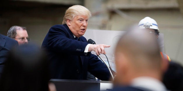 Republican presidential candidate Donald Trump points to a reporter during a campaign event in the atrium of the Old Post Off