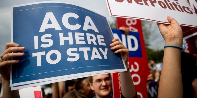 A demonstrator in support of U.S. President Barack Obama's health-care law, the Affordable Care Act (ACA), holds up a 'ACA is Here to Stay' sign after the U.S. Supreme Court ruled 6-3 to save Obamacare tax subsidies outside the Supreme Court in Washington, D.C., U.S., on Thursday, June 25, 2015. The U.S. Supreme Court upheld the nationwide tax subsidies that are a core component of President Barack Obama's health-care law rejecting a challenge that had threatened to gut the measure and undercut his legacy. Photographer: Andrew Harrer/Bloomberg via Getty Images