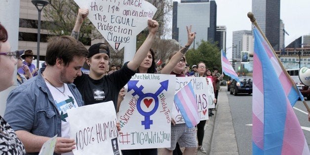 Demonstrators protesting passage of legislation limiting bathroom access for transgender people stand in front of the Charlot