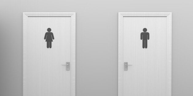 Two closed restroom doors with gender symbol signs designating male and female public toilets.