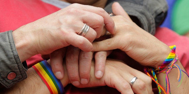 People hold hands during a protest demanding the rights of the lesbian, gay, bisexual, and transgender (LGBT) community, at the Congress building in Bogota November 27, 2012. The protest was also against Senator Roberto Gerlein's recent derogatory comments on homosexuality during a debate on a proposed gay marriage bill in Congress, according to local media. REUTERS/John Vizcaino (COLOMBIA - Tags: SOCIETY CIVIL UNREST POLITICS)