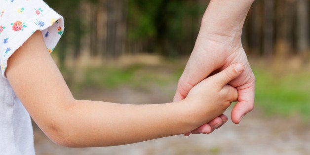 mother holding a hand of her...